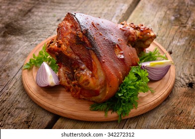 Baked Eisbein With Wegetables On Wooden Board.