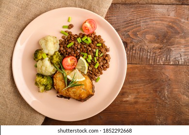 Baked Fish With Broccoli And Lentils In A Beige Plate On A Linen Napkin. Copy Space.