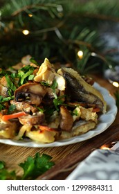 Baked fish with mushrooms on a white plate on a wooden disc sprinkled with parsley