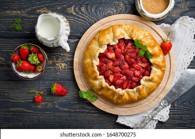 Baked galette or open strawberry pie on the table. Homemade pastry