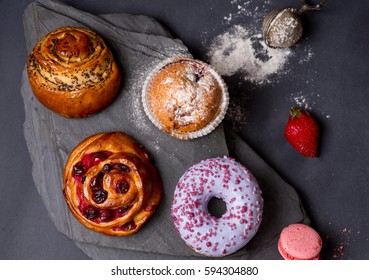 Lot Of Baked Goods And Sweets On A Dark Table