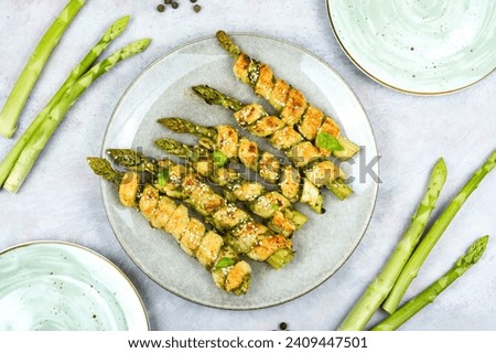 Baked green asparagus in puff pastry on the plate. Healthy food.
