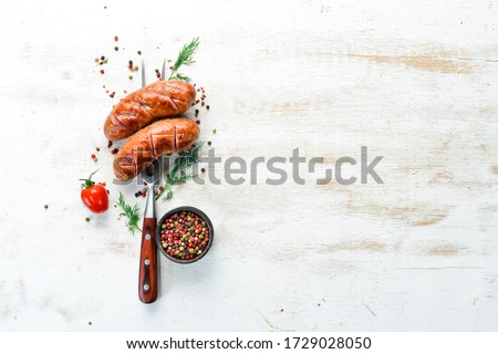 Baked grilled sausages on a fork. BBQ menu. Top view.