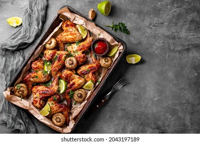 Baked homemade chicken wings with mushrooms and lime, top view, copy space for text. High quality photo