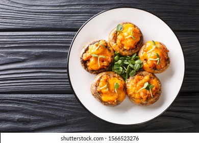 Baked Hot Mushrooms Stuffed With Minced Meat And Cheddar Cheese Close-up On A Plate On The Table. Horizontal Top View From Above
