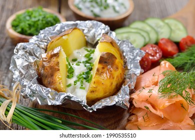 Baked jacket potato fresh from the oven served with chives sour cream and smoked salmon 