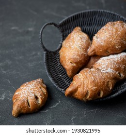 Baked leaf-shaped buns in basket on gray background. Fresh pastries food for breakfast concept. Square format or 1x1 for posting on social media.