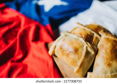 Baked meat chilean empanadas on the chilean flag. Copy space. Independence day concept. Selective focus - Shutterstock ID 2177308733