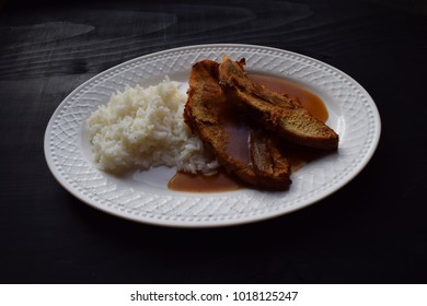 baked meats and rice on a withe plate