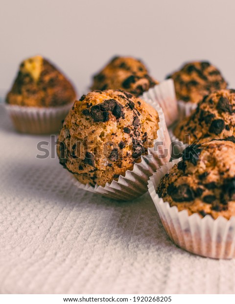 Baked muffins with chocolate chips.\
White background of chocolate muffins with copy\
space.