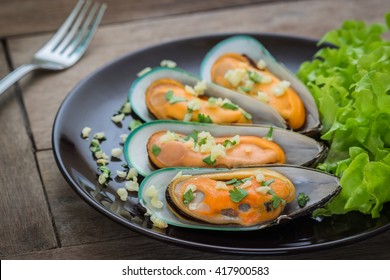 Baked mussels with garlic on plate