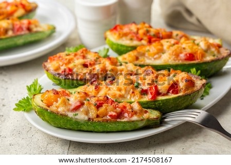 Baked in oven Zucchini stuffed with chicken meat, belle peppers, tomatoes and cheese. Close-up.