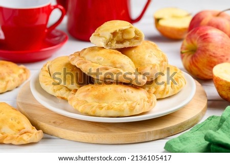 Baked  pasties stuffed with apples. Pirozhki - russian baked puff pastry with apple fillings. Homemade fruit pies. Selective focus