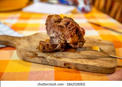 Baked piece of juicy peeled shoulder beef (clod, or fake sirloin) with jelly tendon full of collagen on wooden kitchen board on table with rural checkered tablecloth. - Shutterstock ID 1862528302