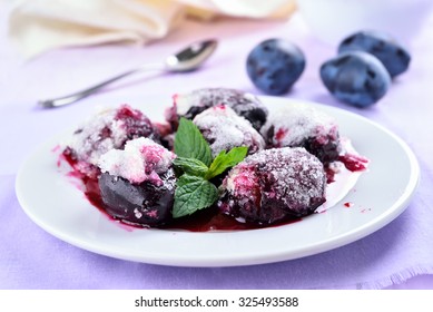 Baked Plums With Sugar On White Plate