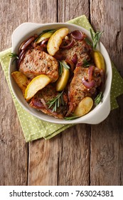 Baked Pork Fillet With Green Apples, Onions And Rosemary Close-up In A Dish. Vertical Top View From Above
