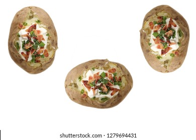 Baked Potato. Three Hot Fresh Baked Russet Potatoes With Butter, Sour Cream, Bacon Bits, And Chives. Isolated On White. Room For Text. Potatoes Are Easily Moved Or Enlarged To Fit Your Needs. 
