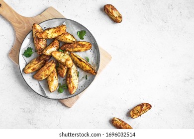 Baked potato wedges with cheese and herbs  - homemade organic vegetable vegan vegetarian potato wedges snack food meal, top view, copy space. - Powered by Shutterstock