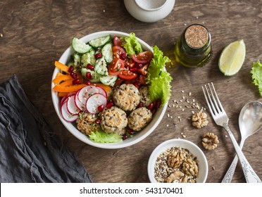 Baked quinoa meatballs and vegetable salad on a wooden table, top view.  Buddha bowl. Healthy, diet, vegetarian food concept. Flat lay  