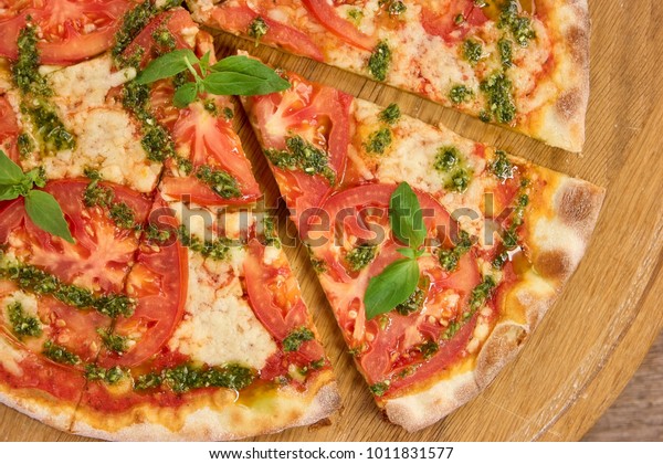 Baked removed pizza slice. Delicious divided\
tomato pizza slices.