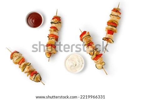Baked roasted Chicken meat with vegetables, sweet pepper, zucchini and sauces, kebab on skewers isolated on a white background. Top view.