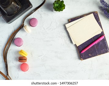 baked round macarons, notebook, pen and plants in a pot on a white background, top view, empty space - Powered by Shutterstock