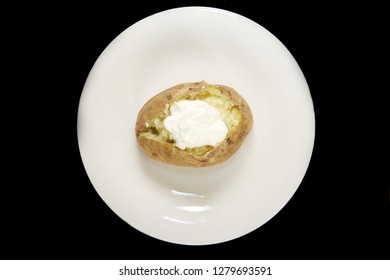 Baked Russet Potato. Hot Baked Russet Potato On A White Plate With Fresh Butter And Sour Cream. Isolated On Black. Room For Text. 
