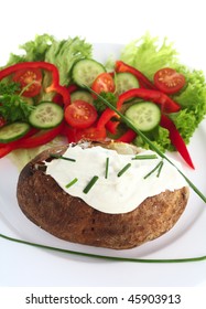 A Baked Russet Potato Topped With A Cream Cheese And Chives Mixture, Served With A Fresh Salad