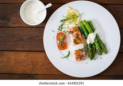 Baked Salmon Garnished With Asparagus And Tomatoes With Herbs. Top View