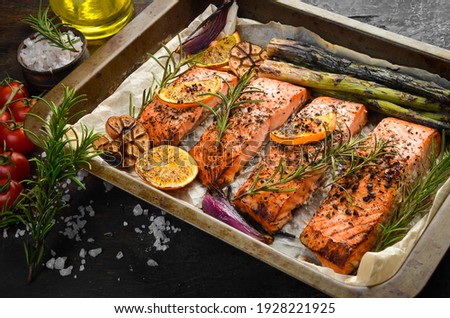 Baked Salmon with rosemary, lemon and vegetables. Recipe. Seafood. Side view Free space for text.