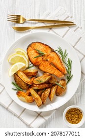 Baked Salmon Steak And Roasted Potatoes On A White Plate, Vertical View From Above