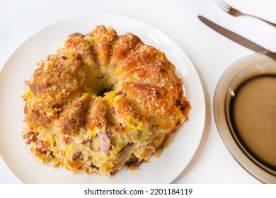 Baked Salty Tart On Plate. Boiled Pasta With Mixed Egg And Piece Of Smoked Meat Baked In Cake Tin On Plate, Cutlery And Empty Plate On White Background.