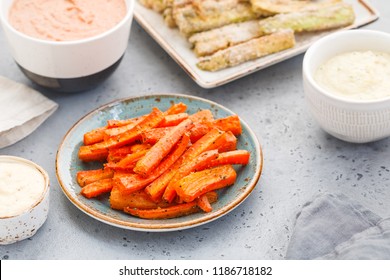 Baked Season Carrot Sticks With Sauce And Hummus On A Dinner Table. Vegetarian Healthy Food. 