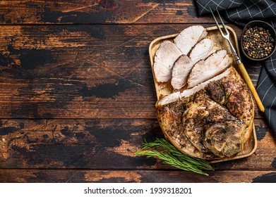 Baked sliced pork leg knuckle. Dark wooden background. Top view. Copy space