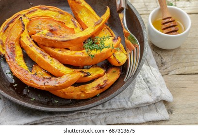 Baked slices of pumpkin with thyme and honey. Healthy dessert for gourmets. Selective focus