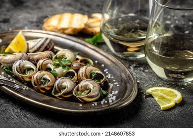 Baked snails with butter and spice on dark background. Snails baked with sauce, Bourgogne Escargot Snails. gourmet food. concept of french cuisine, Long banner format. top view. - Shutterstock ID 2148607853
