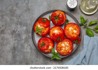 Baked stuffed tomatoes with rice and cheese. Top view. Grey table, copy space.