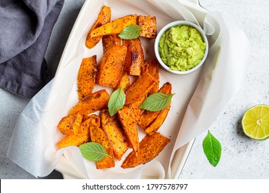 Baked Sweet Potato Wedges With Avocado Dip. Healthy Vegan Food Concept.