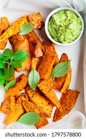 Baked Sweet Potato Wedges With Avocado Dip. Healthy Vegan Food Concept.