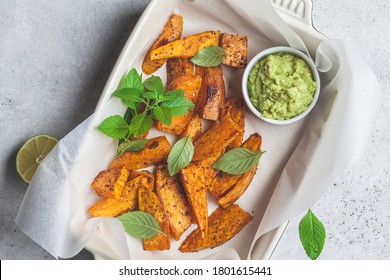 Baked Sweet Potato Wedges With Avocado Dip. Healthy Vegan Food Concept.