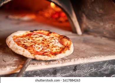 Baked Tasty Margherita Pizza In Traditional Wood Oven In Naples Restaurant, Italy. Original Neapolitan Pizza. Red Hot Coal.