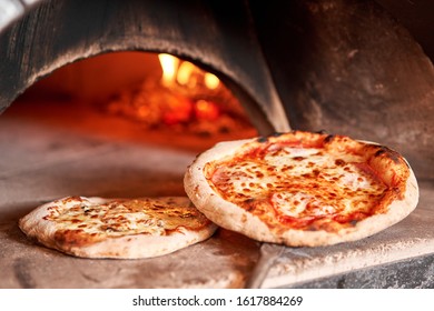 Baked Tasty Margherita Pizza In Traditional Wood Oven In Naples Restaurant, Italy. Original Neapolitan Pizza. Red Hot Coal.