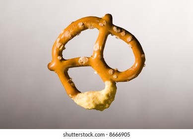 A Baked Twisted Pretzel With A Mustard Dip