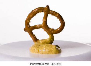 A Baked Twisted Pretzel With A Mustard Dip