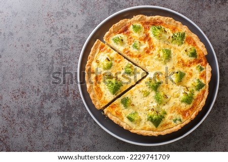 Baked vegetable quiche with romanesco broccoli, eggs and cheese close-up in a plate on the table. Horizontal top view from above
