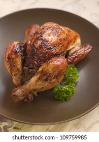Baked whole chicken with parsley for dinner, selective focus