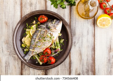 Baked Whole Fish, Served With Roasted Vegetables And Lemon. Top View.