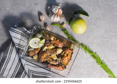 Baked Whole Garlic Chicken With Lemon And Spices, Photograph In Flatlay And Low Key.