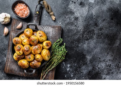 Baked Youg Potato With Thyme In A Pan Black Background. Top View. Copy Space