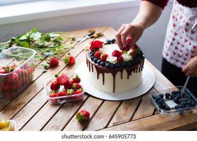 Baker Adding Blueberries To A Cake